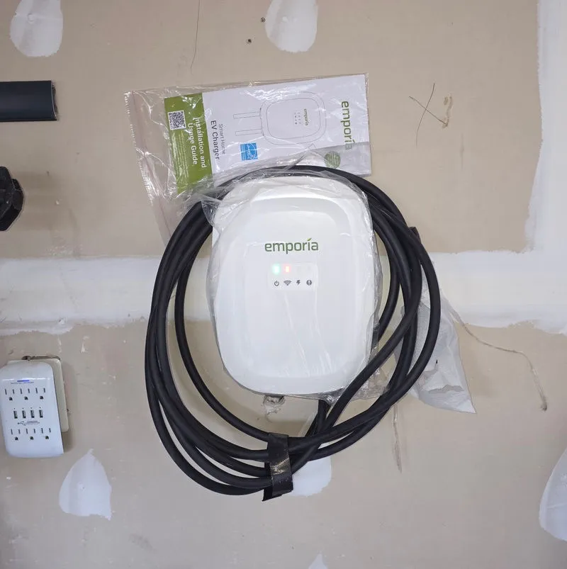 Level 2 EV charger installed beside a garage parking space