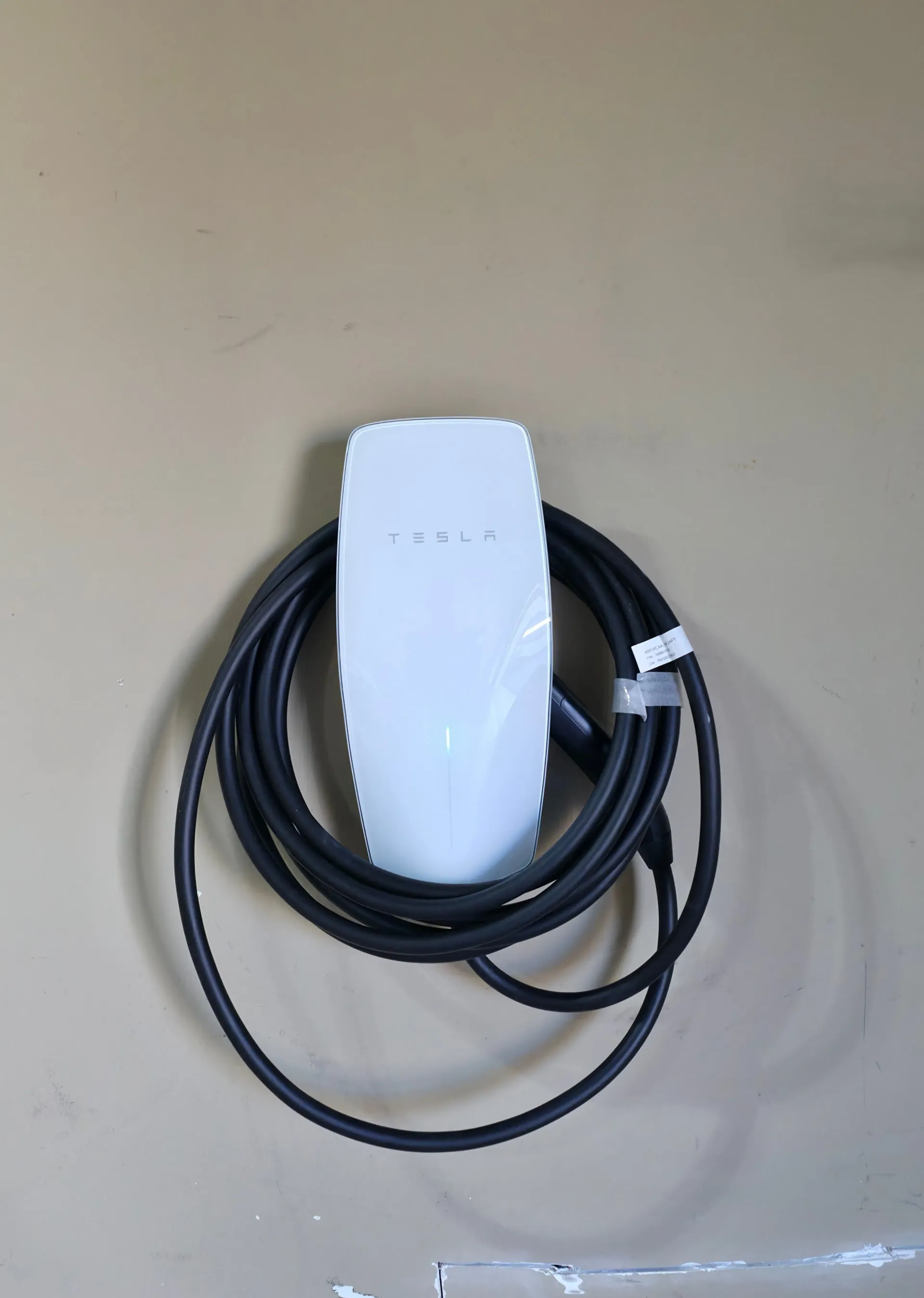 Tesla Wall Connector mounted on an interior wall in South Riding, Virginia, with the charging cable coiled
